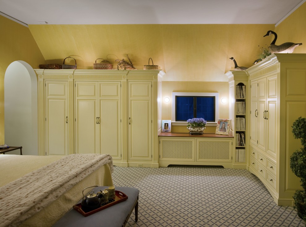 Diseño de dormitorio principal clásico grande con paredes amarillas, moqueta, todas las chimeneas, marco de chimenea de madera y suelo beige