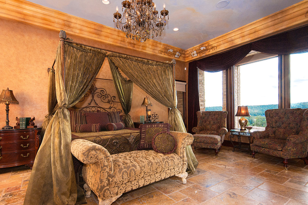 Стильный дизайн: огромная хозяйская спальня в средиземноморском стиле с бежевыми стенами, полом из травертина и фасадом камина из камня - последний тренд