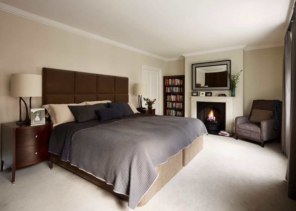 Large trendy master carpeted bedroom photo in London with beige walls, a standard fireplace and a stone fireplace