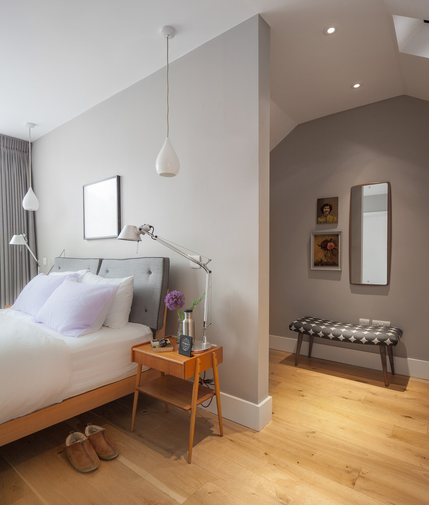 Small elegant master light wood floor and brown floor bedroom photo in London with gray walls