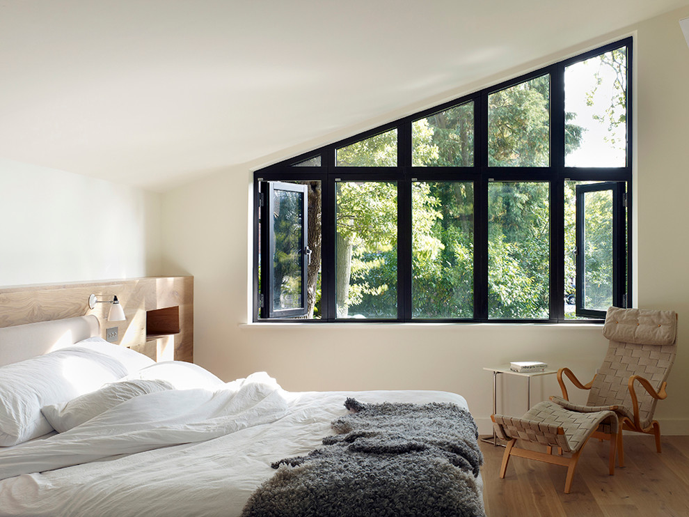Diseño de dormitorio contemporáneo de tamaño medio con paredes blancas, suelo de madera en tonos medios y suelo marrón