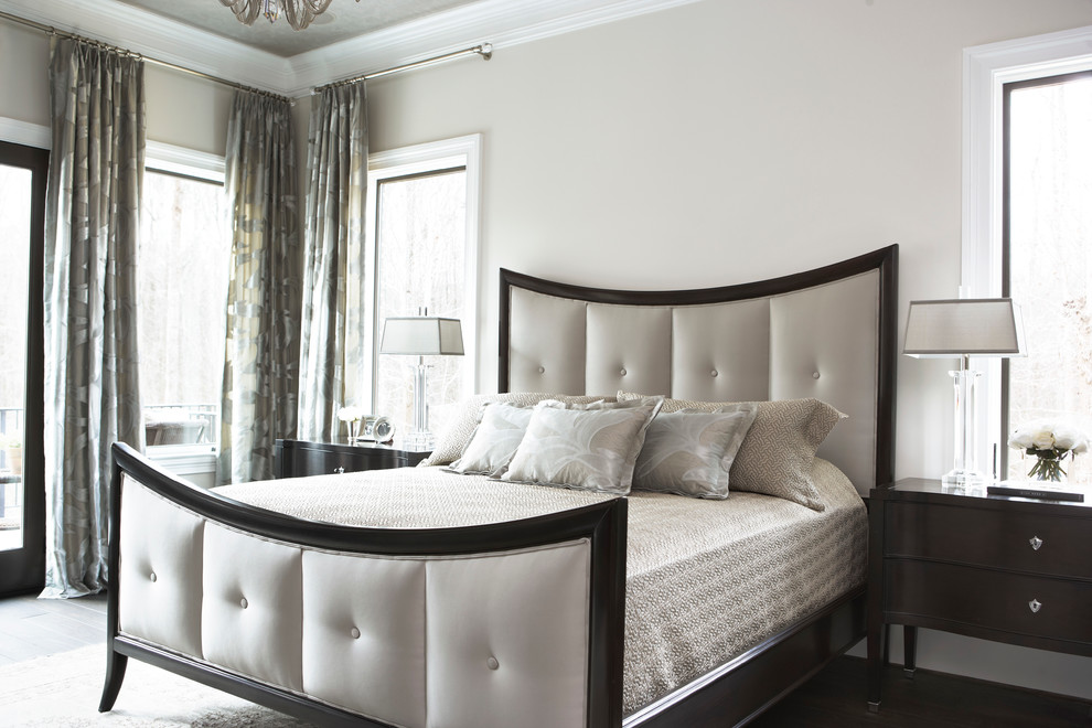 На фото: большая хозяйская спальня в классическом стиле с темным паркетным полом и белыми стенами