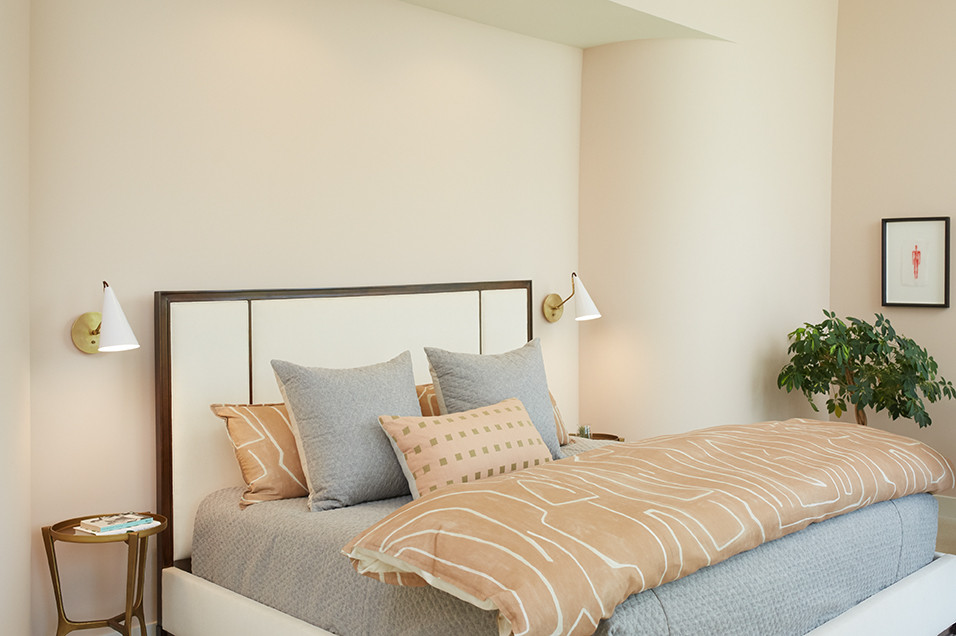На фото: большая хозяйская спальня в стиле ретро с розовыми стенами, светлым паркетным полом, стандартным камином и коричневым полом