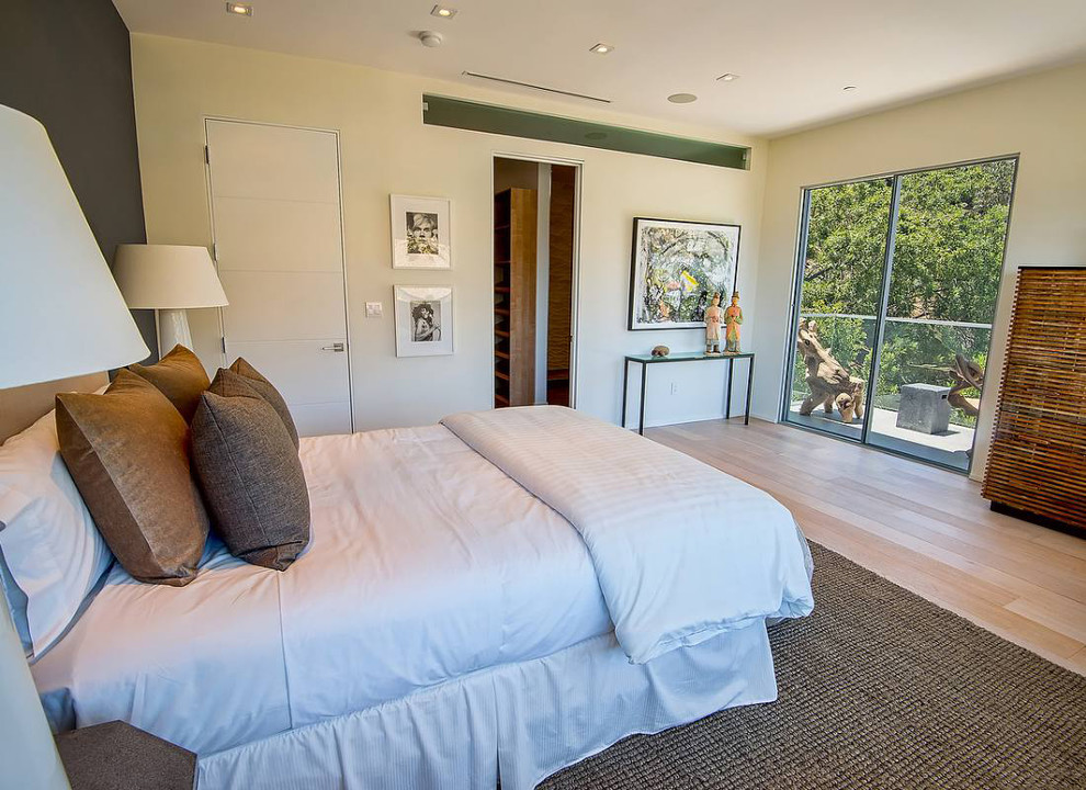 Foto di una camera degli ospiti minimalista di medie dimensioni con pareti bianche, parquet chiaro e nessun camino