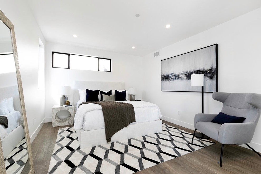 На фото: гостевая спальня (комната для гостей) в современном стиле с белыми стенами, паркетным полом среднего тона и коричневым полом без камина