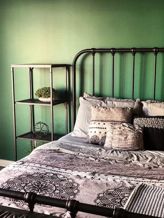 Cette image montre une petite chambre mansardée ou avec mezzanine urbaine avec un mur vert, sol en béton ciré et un sol gris.