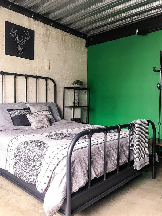Kleines Industrial Schlafzimmer im Loft-Style mit grüner Wandfarbe, Betonboden und grauem Boden in Los Angeles