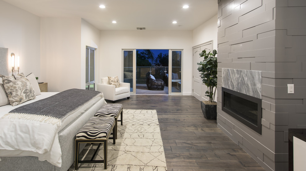 ロサンゼルスにある広いコンテンポラリースタイルのおしゃれな主寝室 (白い壁、濃色無垢フローリング、横長型暖炉、石材の暖炉まわり、茶色い床) のインテリア