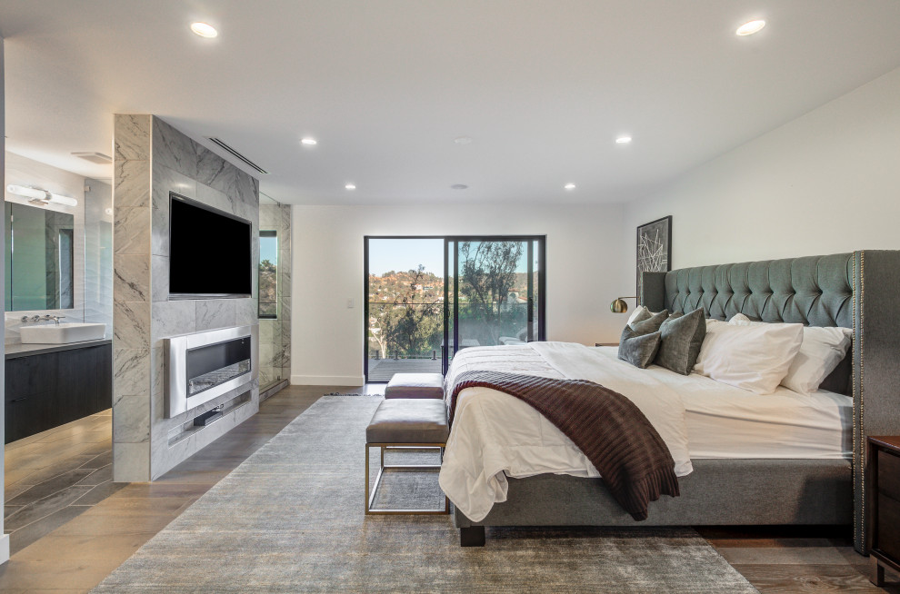 Идея дизайна: большая хозяйская спальня в современном стиле с паркетным полом среднего тона, горизонтальным камином, фасадом камина из плитки и серым полом