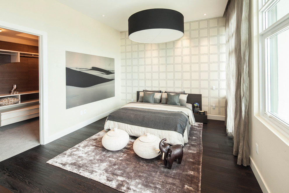 Aménagement d'une chambre contemporaine avec un mur beige, parquet foncé et dressing.