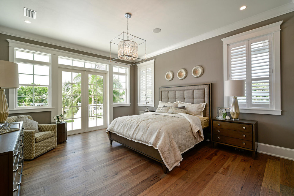 Modelo de dormitorio principal tradicional renovado grande con paredes marrones, suelo de madera en tonos medios y suelo marrón
