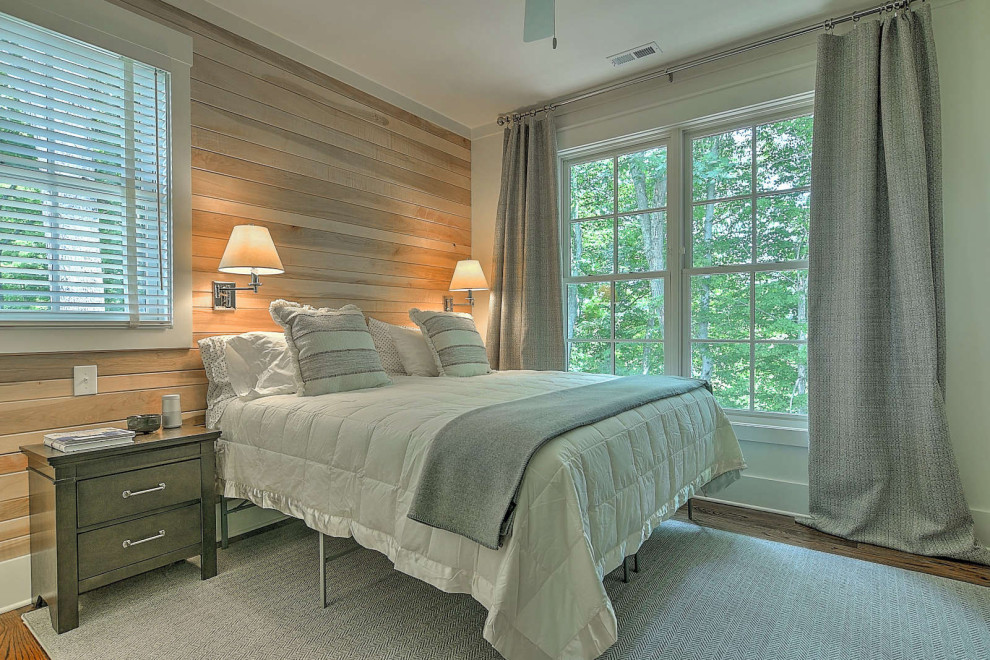 Modelo de dormitorio principal rural pequeño con paredes beige, suelo de madera en tonos medios y machihembrado