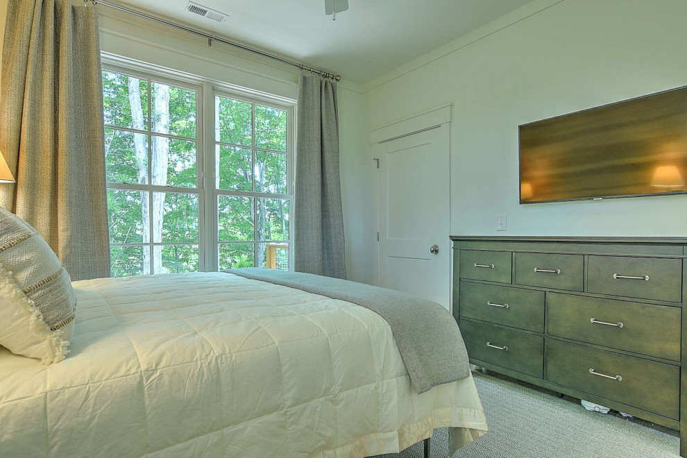 Cette image montre une petite chambre d'amis chalet avec un mur beige, un sol en bois brun et du lambris de bois.