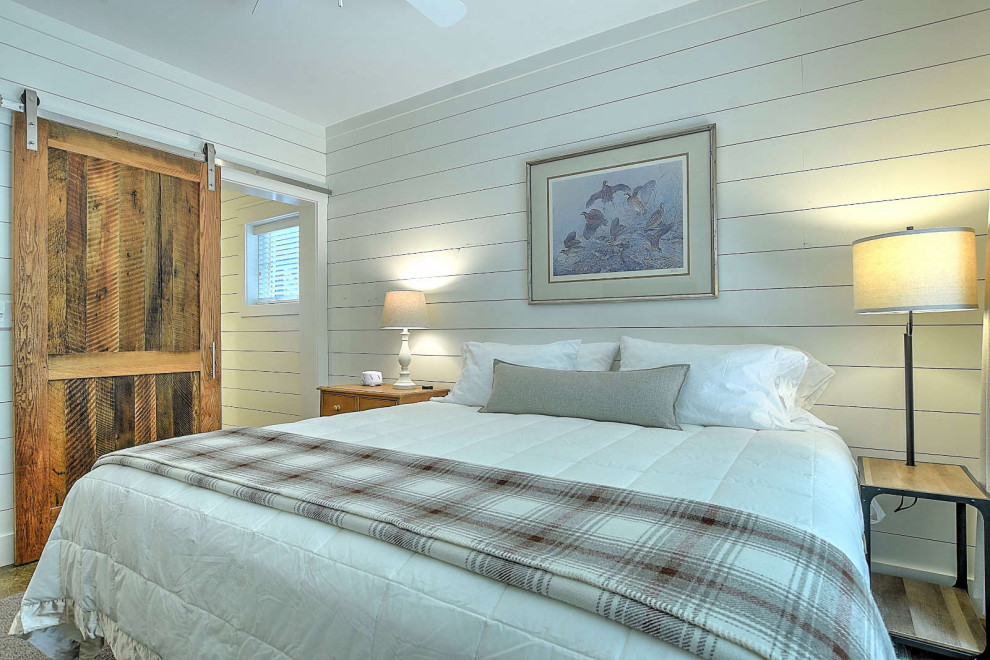 Esempio di una piccola camera degli ospiti stile rurale con pareti beige, pavimento in legno massello medio e pareti in perlinato