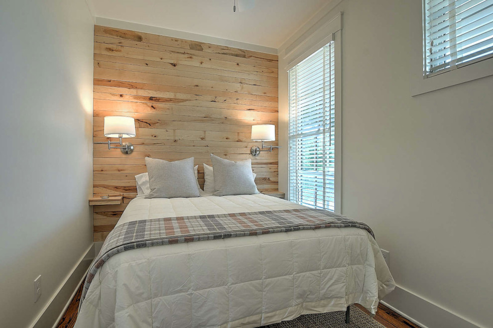 Inspiration pour une petite chambre d'amis chalet avec un mur beige, un sol en bois brun et du lambris de bois.