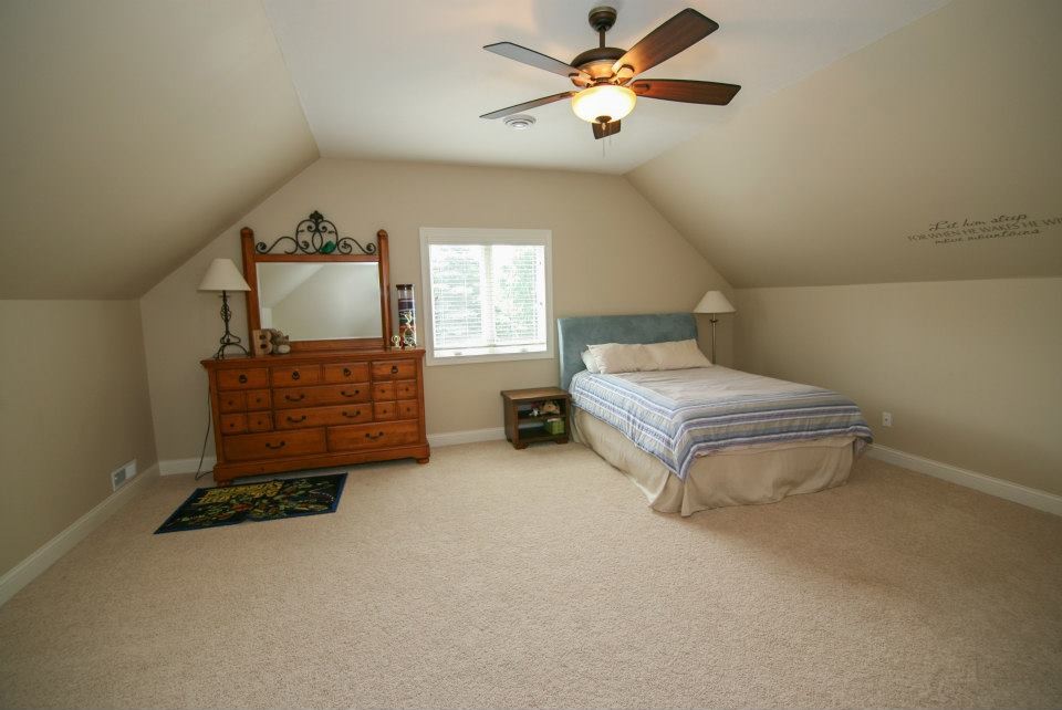 Design ideas for a large classic guest bedroom in Cleveland with beige walls and carpet.