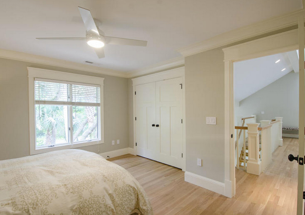 Foto de habitación de invitados costera grande con paredes grises y suelo de madera clara