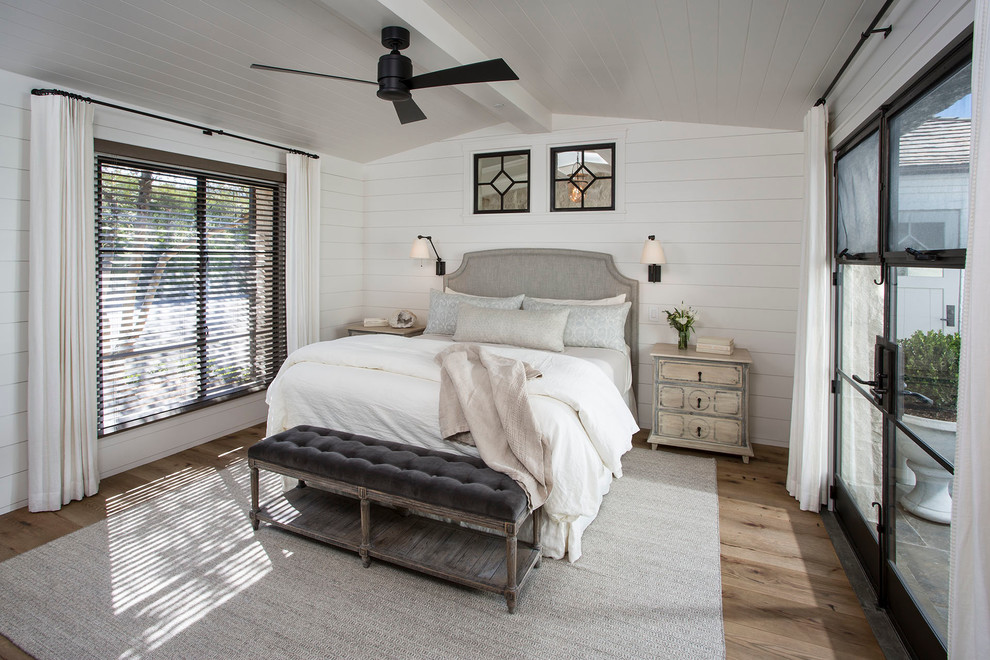 Photo of a coastal bedroom in Boise with white walls and medium hardwood flooring.