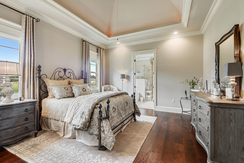 Imagen de dormitorio principal tradicional renovado de tamaño medio con paredes beige, suelo de madera en tonos medios y suelo marrón