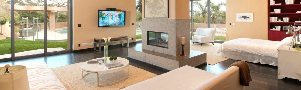 マイアミにある巨大なコンテンポラリースタイルのおしゃれな主寝室 (ベージュの壁、両方向型暖炉、タイルの暖炉まわり、濃色無垢フローリング、茶色い床) のインテリア