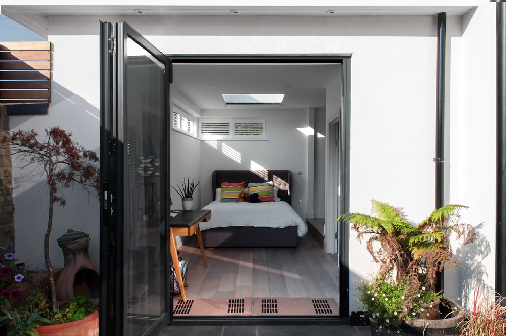 Immagine di una camera degli ospiti minimalista di medie dimensioni con pavimento in legno massello medio