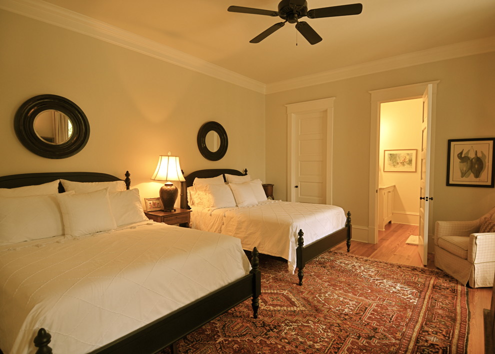 Elegant guest medium tone wood floor bedroom photo in Charleston with beige walls