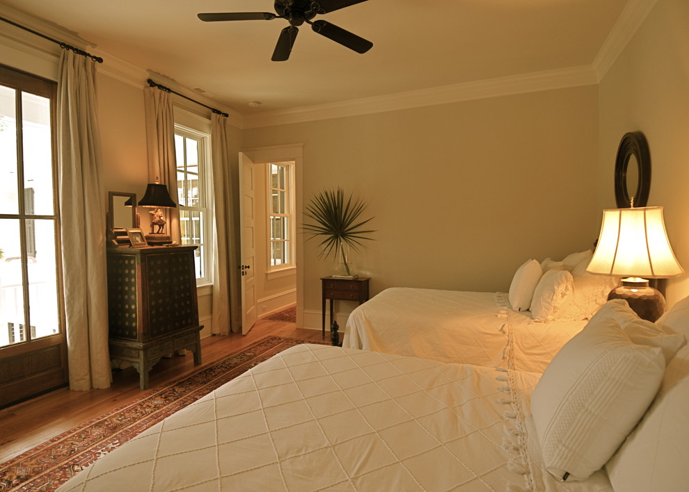Idées déco pour une chambre d'amis classique avec un mur beige et un sol en bois brun.