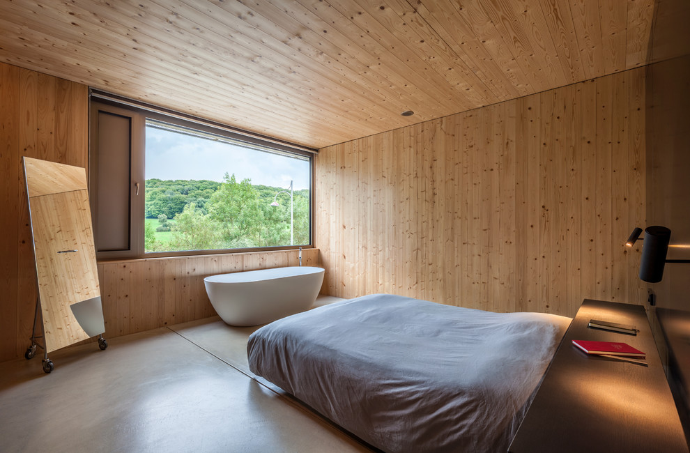 Foto på ett funkis sovrum, med bruna väggar, betonggolv och grått golv