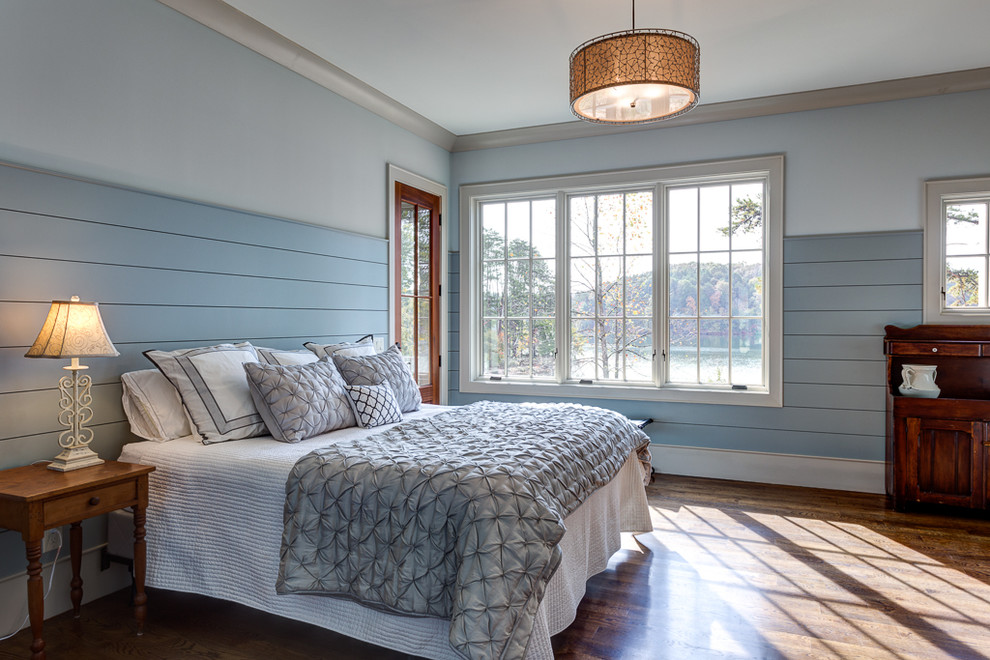 Idee per una camera matrimoniale stile marino di medie dimensioni con pareti blu, parquet scuro, camino classico e cornice del camino in pietra