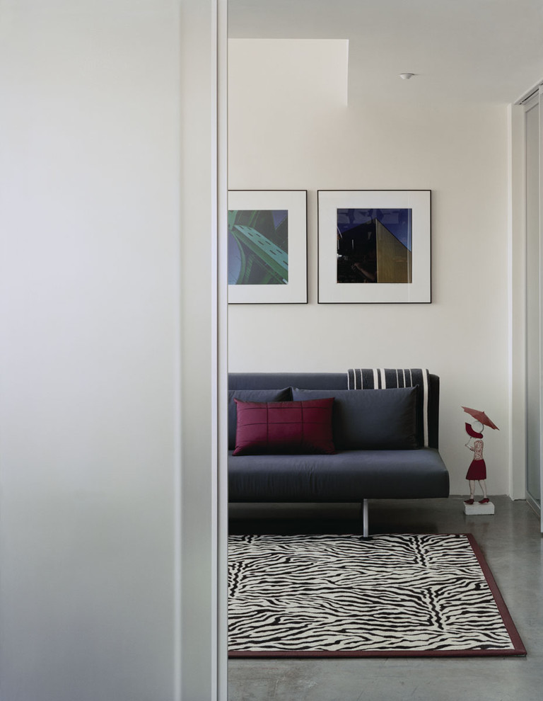 Imagen de dormitorio minimalista con paredes blancas y suelo de cemento