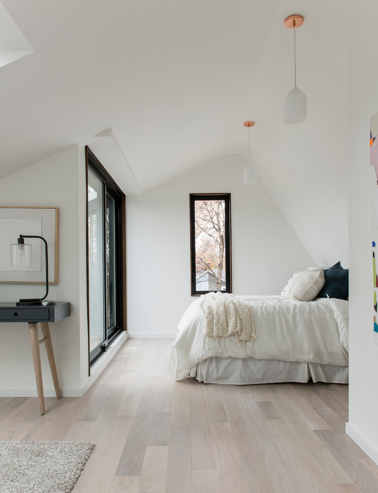 Modelo de dormitorio actual grande con paredes blancas, suelo de madera clara y suelo beige