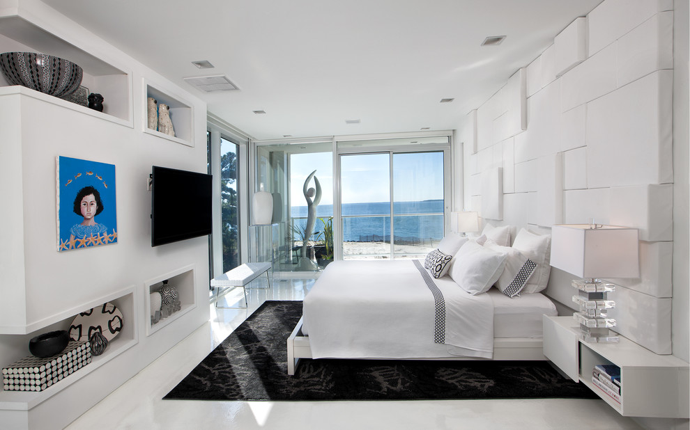 На фото: большая хозяйская спальня в стиле модернизм с белыми стенами и бетонным полом без камина с