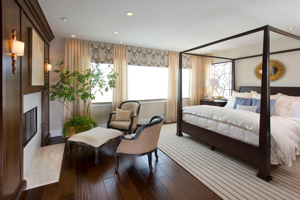 Exempel på ett modernt sovrum, med beige väggar, mörkt trägolv och en bred öppen spis