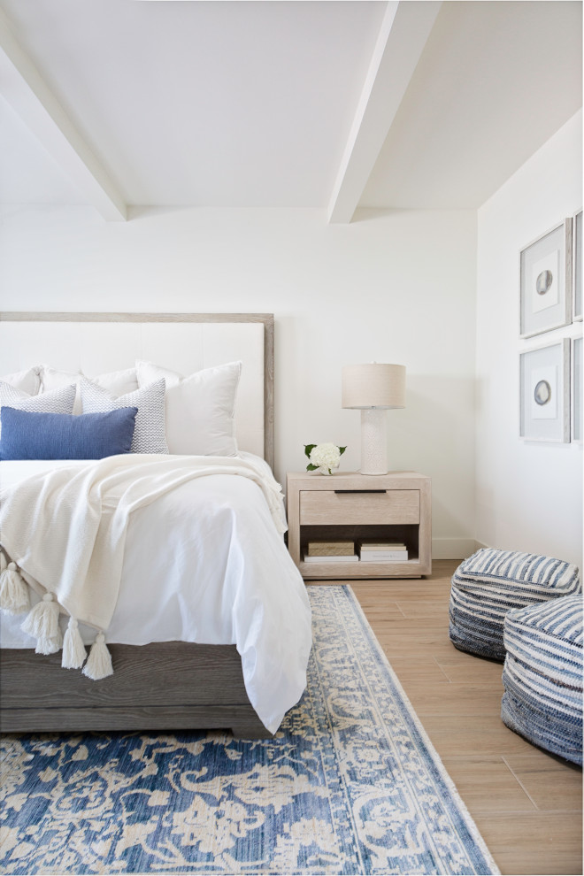 Foto di una camera da letto chic con pareti bianche e pavimento marrone