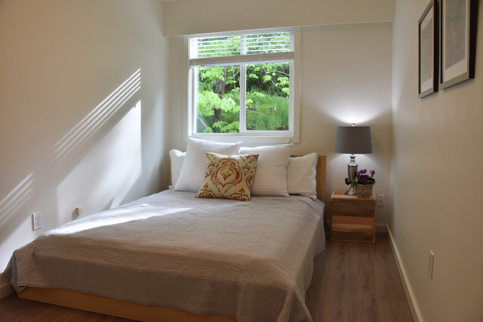 Esempio di una piccola camera degli ospiti contemporanea con pareti bianche, pavimento in legno massello medio, nessun camino e pavimento marrone