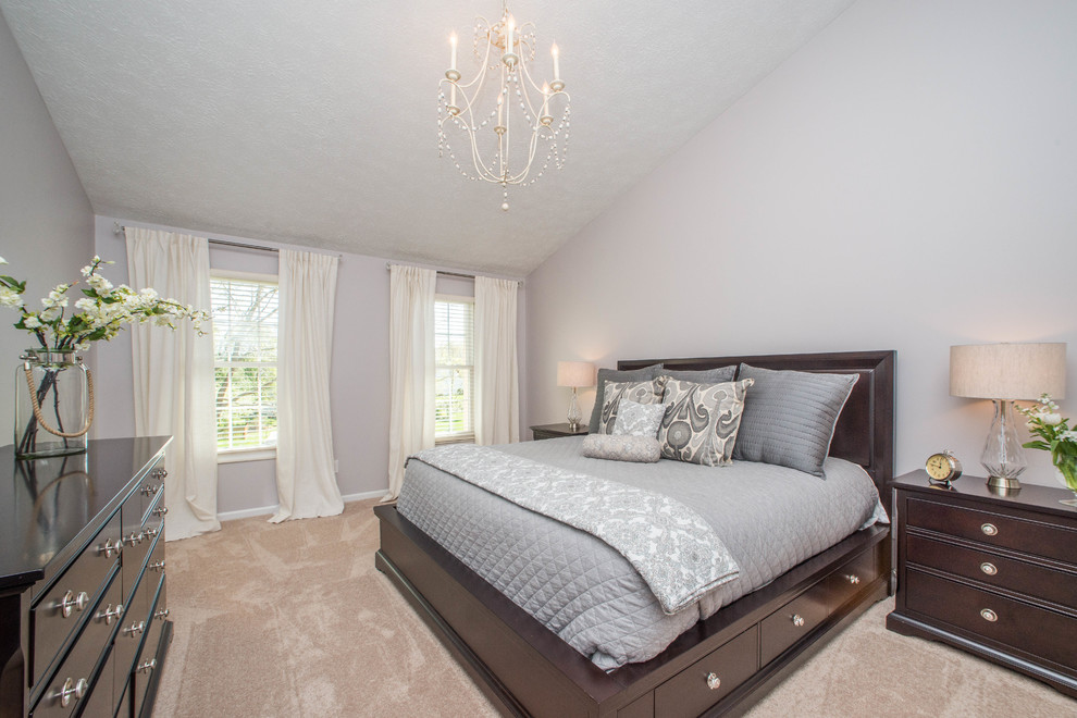 This is an example of a large traditional master bedroom in Other with grey walls, carpet and beige floors.