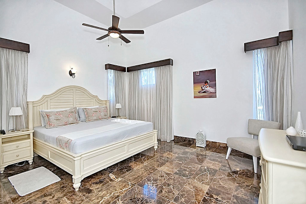 На фото: большая хозяйская спальня в стиле модернизм с белыми стенами, мраморным полом и коричневым полом без камина с