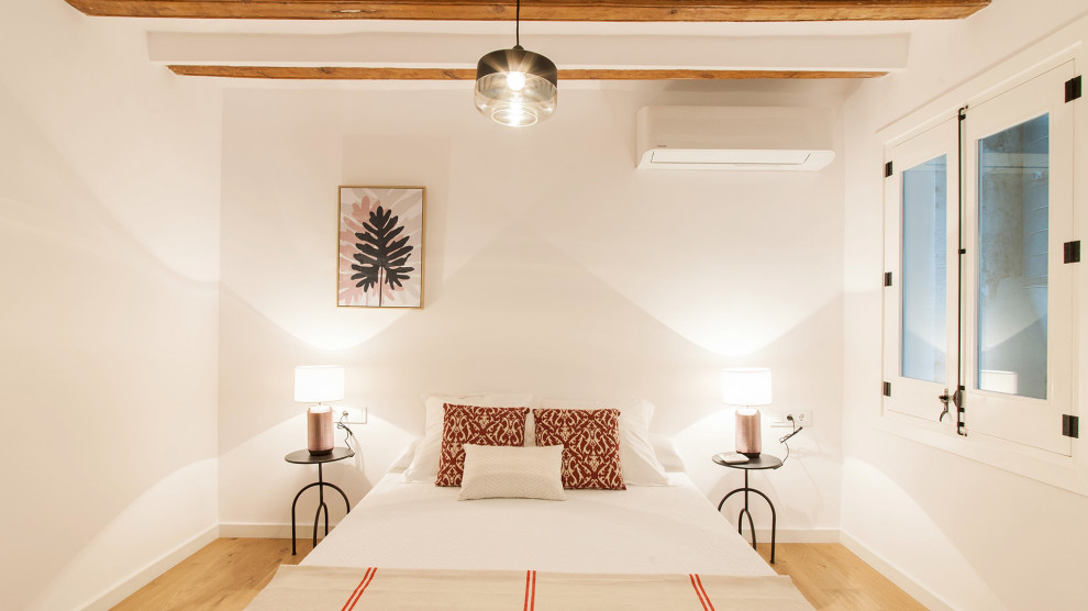 Kleines Skandinavisches Hauptschlafzimmer mit weißer Wandfarbe und hellem Holzboden in Barcelona