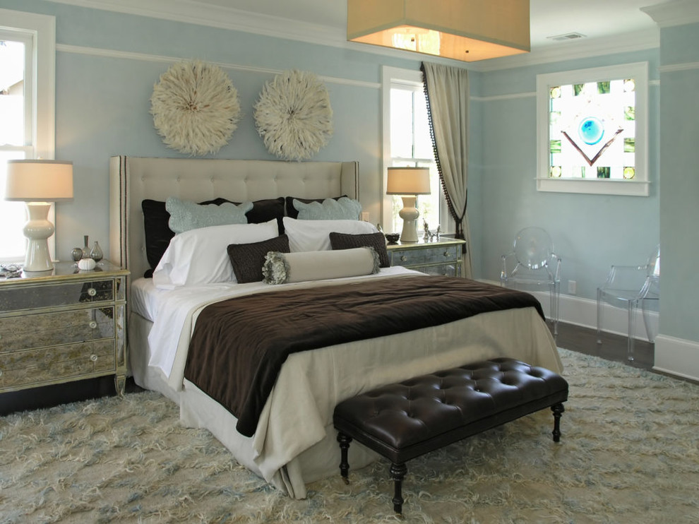 Diseño de dormitorio principal costero grande sin chimenea con paredes azules, suelo de madera oscura y suelo marrón