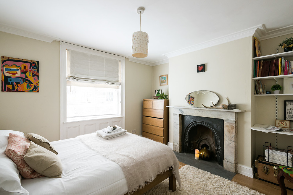 Diseño de dormitorio contemporáneo con paredes beige, suelo de madera en tonos medios y todas las chimeneas