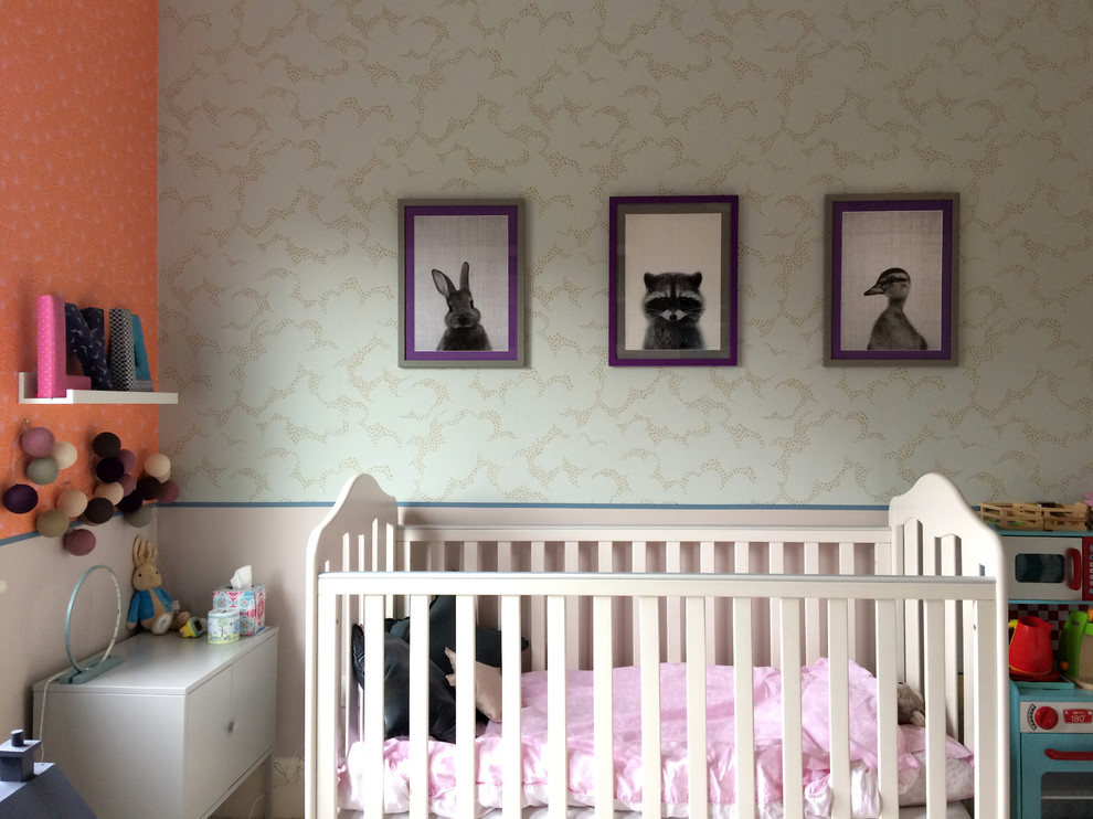 Photo of a medium sized contemporary nursery in London with multi-coloured walls and carpet.