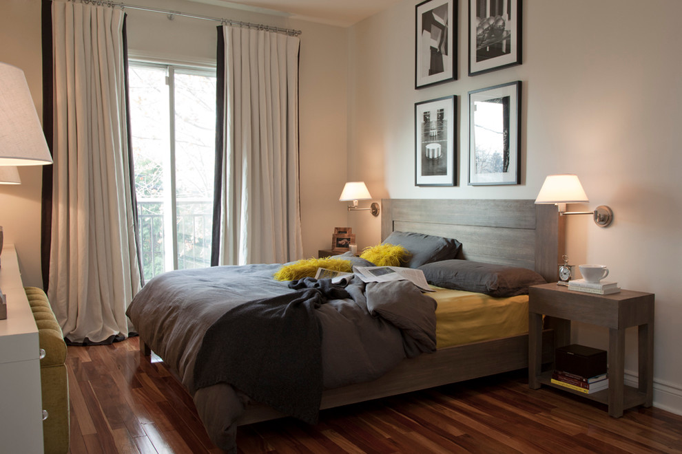 Modelo de dormitorio contemporáneo con paredes beige y suelo de madera oscura