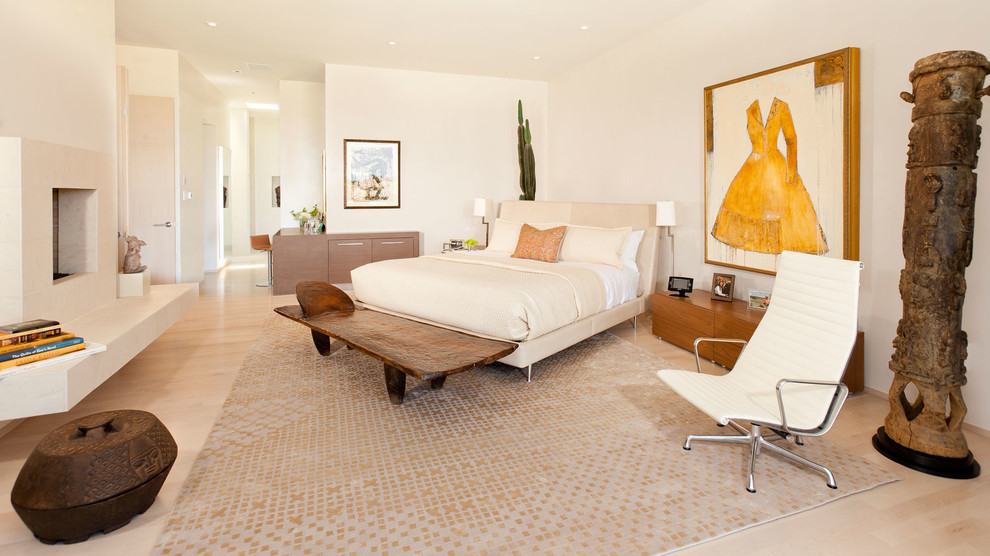 На фото: хозяйская спальня среднего размера в стиле модернизм с белыми стенами, светлым паркетным полом, двусторонним камином и фасадом камина из камня