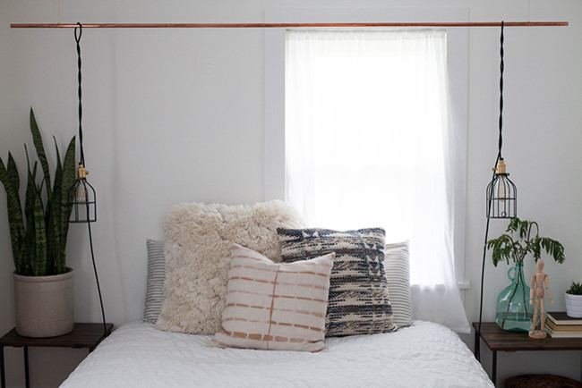 Ejemplo de dormitorio principal ecléctico pequeño sin chimenea con paredes blancas y suelo de madera en tonos medios
