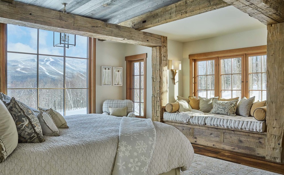 Diseño de dormitorio rural con paredes blancas, suelo de madera en tonos medios y suelo marrón