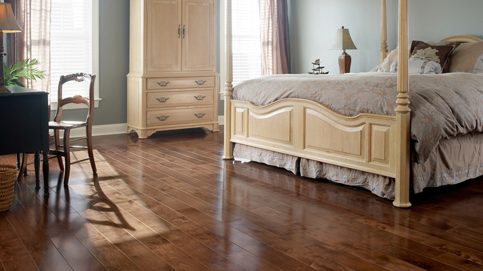 Photo of a traditional master bedroom in Orange County with blue walls and dark hardwood flooring.