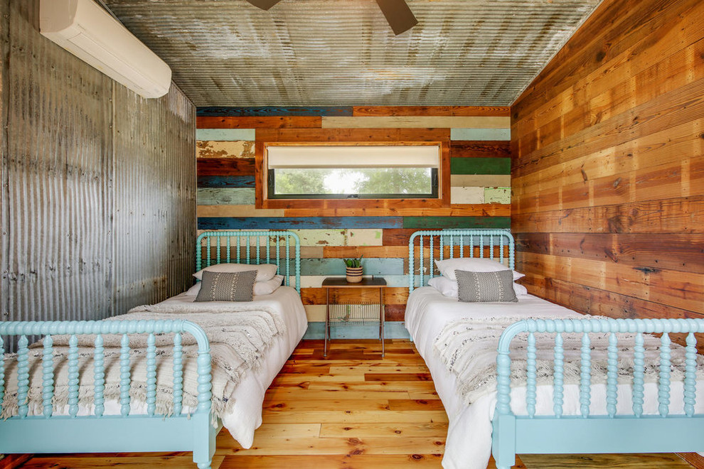 Modelo de habitación de invitados de estilo de casa de campo sin chimenea con paredes multicolor, suelo de madera en tonos medios y suelo marrón