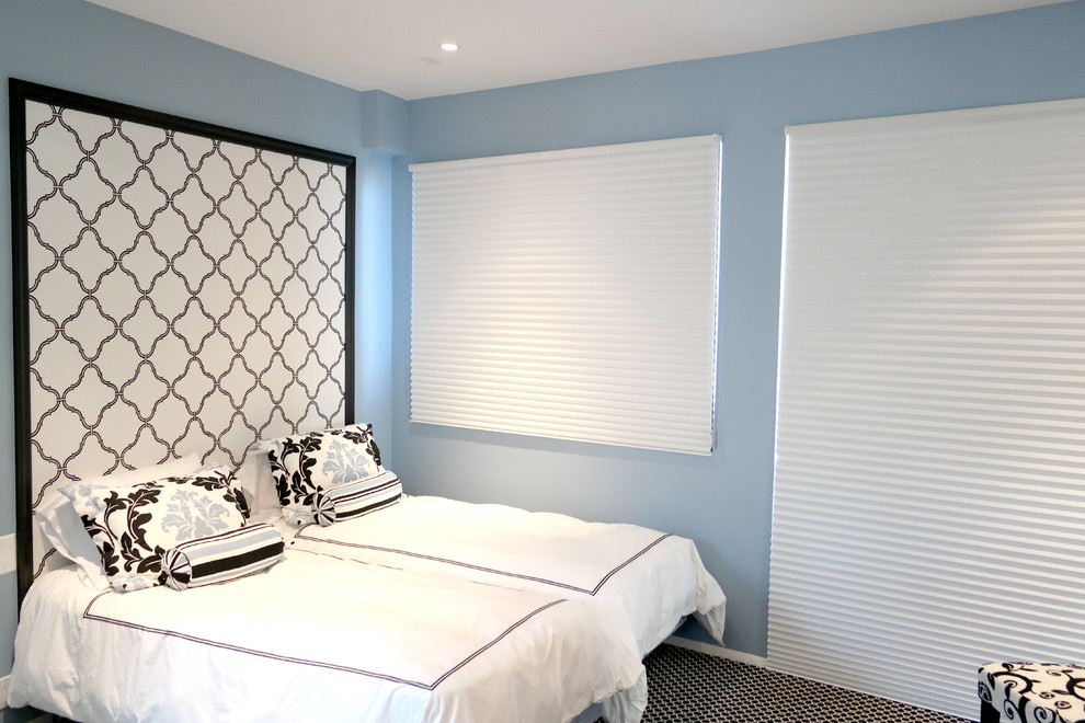 This is an example of a medium sized contemporary guest bedroom in New York with blue walls, carpet and no fireplace.