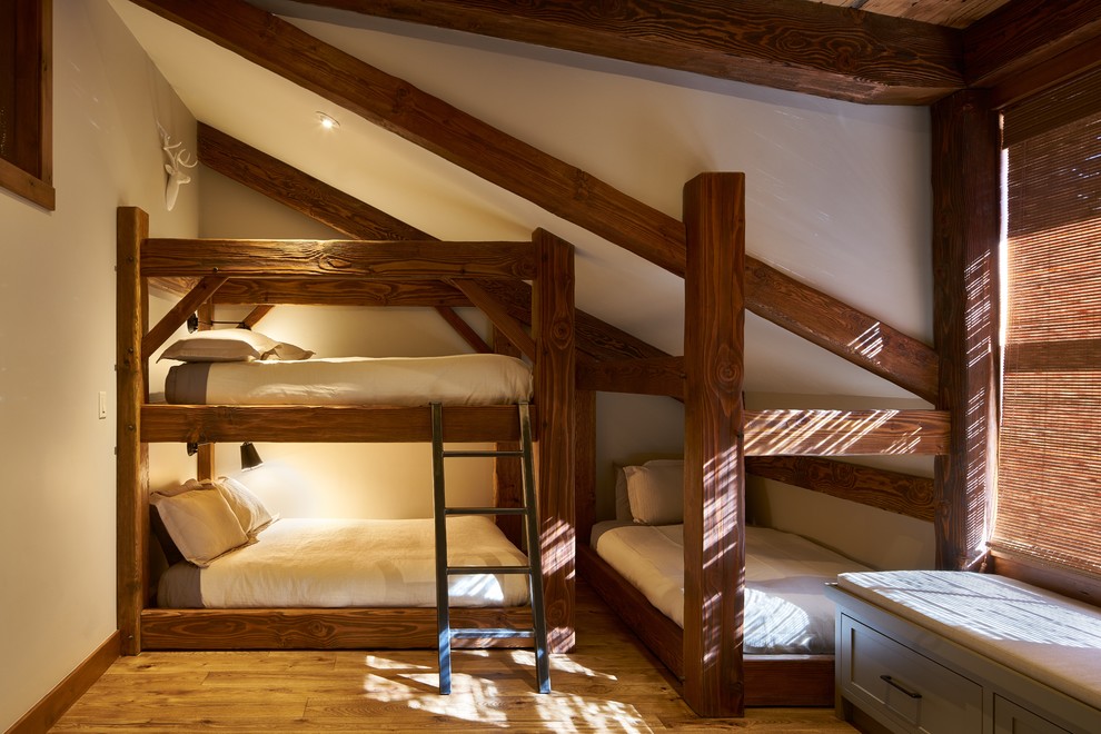 Ispirazione per una camera da letto stile loft stile americano di medie dimensioni con pareti bianche, pavimento in legno massello medio, nessun camino e pavimento marrone