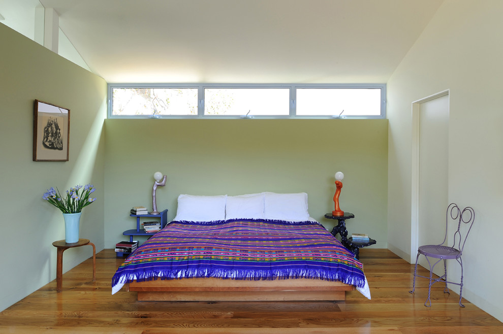 Design ideas for a medium sized contemporary guest bedroom in Los Angeles with medium hardwood flooring, no fireplace, green walls and brown floors.